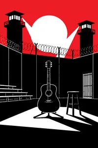 A prison yard stage with a black acoustic guitar on a stand, guard towers and razor wire behind.