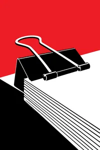 A large black binder clip clamped on a thick stack of paper, its silver handles folded back.