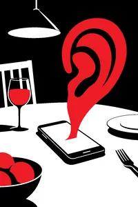A smartphone face-up on a dinner table with a giant cartoon ear rising out of its screen.