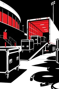 Road cases on wheels being pushed up a ramp into an empty semi trailer behind an arena at night, coils of cable on the pavement.