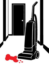 An upright vacuum in a hallway with a chewed rubber toy dropped defiantly beside its wheel.