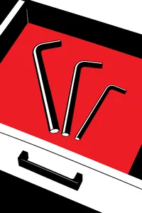 Three small L-shaped hex keys of different sizes fanned out on a wooden drawer bottom.