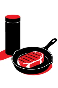 A sealed slim cylindrical box beside a cast-iron skillet with a seared steak in it.