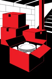 Stacked cardboard boxes in a basement with one flap open showing white porcelain plates nested in foam.