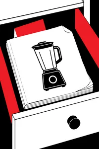 A thick, dog-eared appliance manual with a line drawing of a blender on its blank cover, lying in a drawer, a folded card poking out.