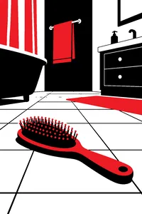 A hairbrush lying bristles up on a tiled bathroom floor.